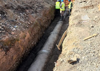 Hombres trabajando en tubería subterránea en obra civil